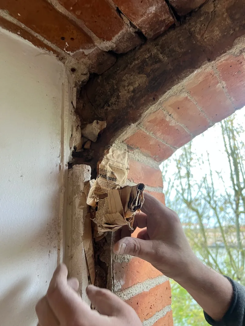 Détail de mur en briques anciennes avec enduit blanc