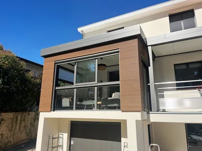 Menuisier installant une porte d'entrée moderne en bois et aluminium