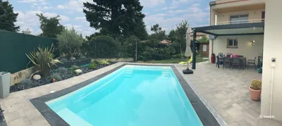 Piscine moderne dans un jardin paysager avec terrasse en bois