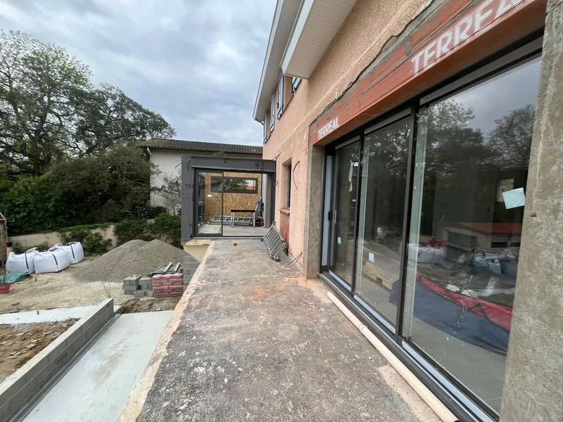 Projet terrasse extérieure avec grandes portes coulissantes vitrées et patio en construction