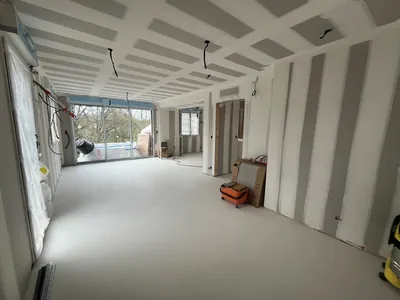 Pièce en cours de rénovation avec des plaques de plâtre au mur et au plafond